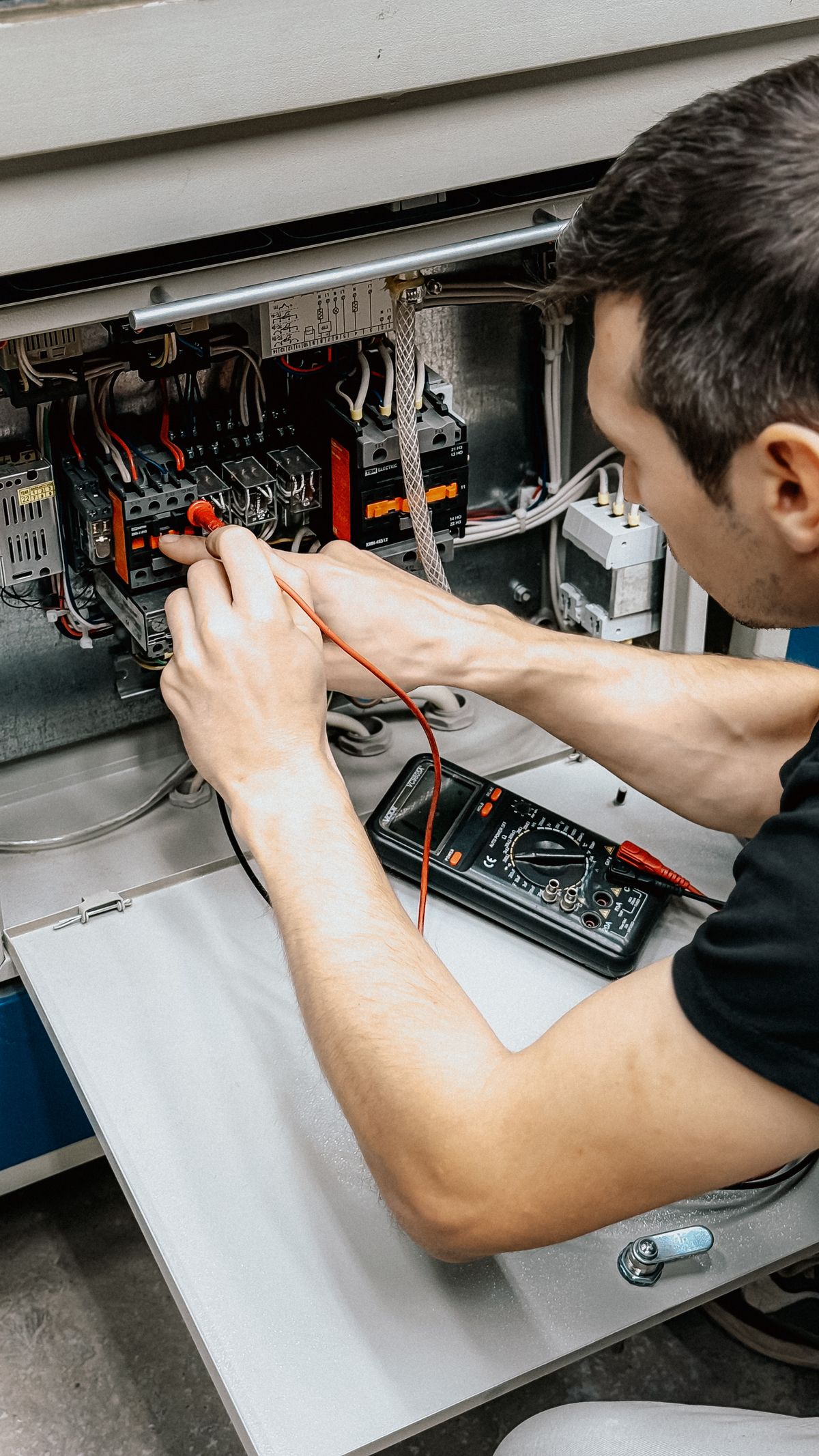 Elektrikář měří rozvaděč multimetrem